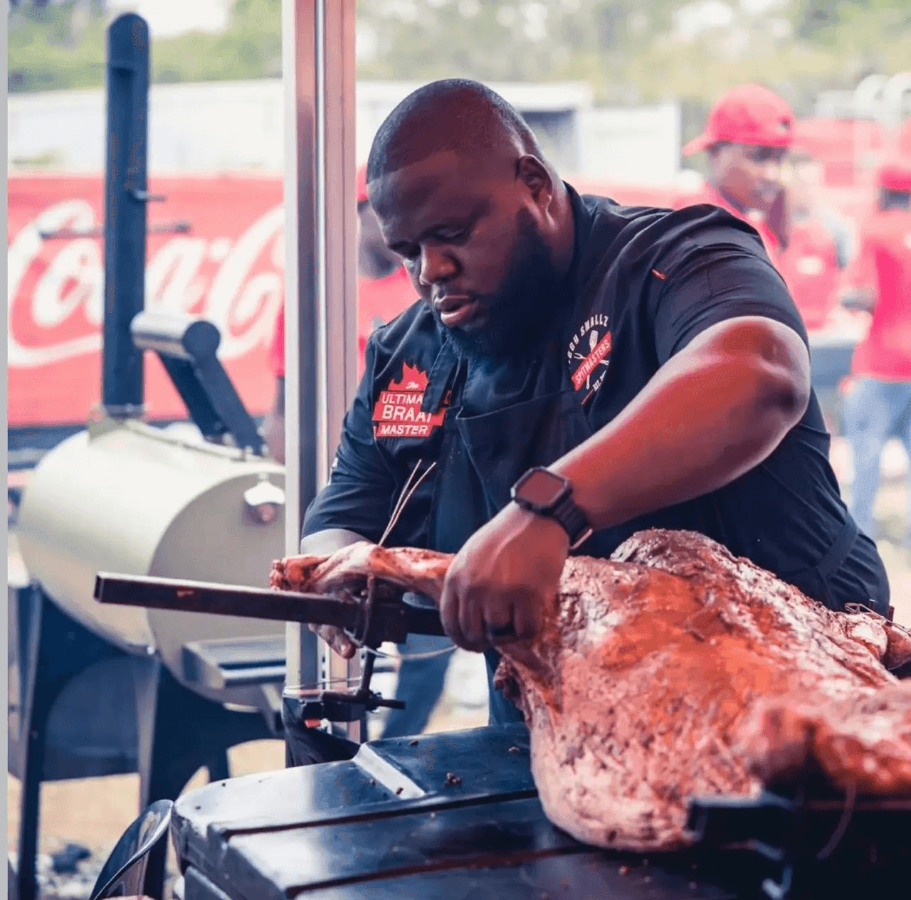 Biggy carving a whole roasted lamb straight off the spit at a festival.