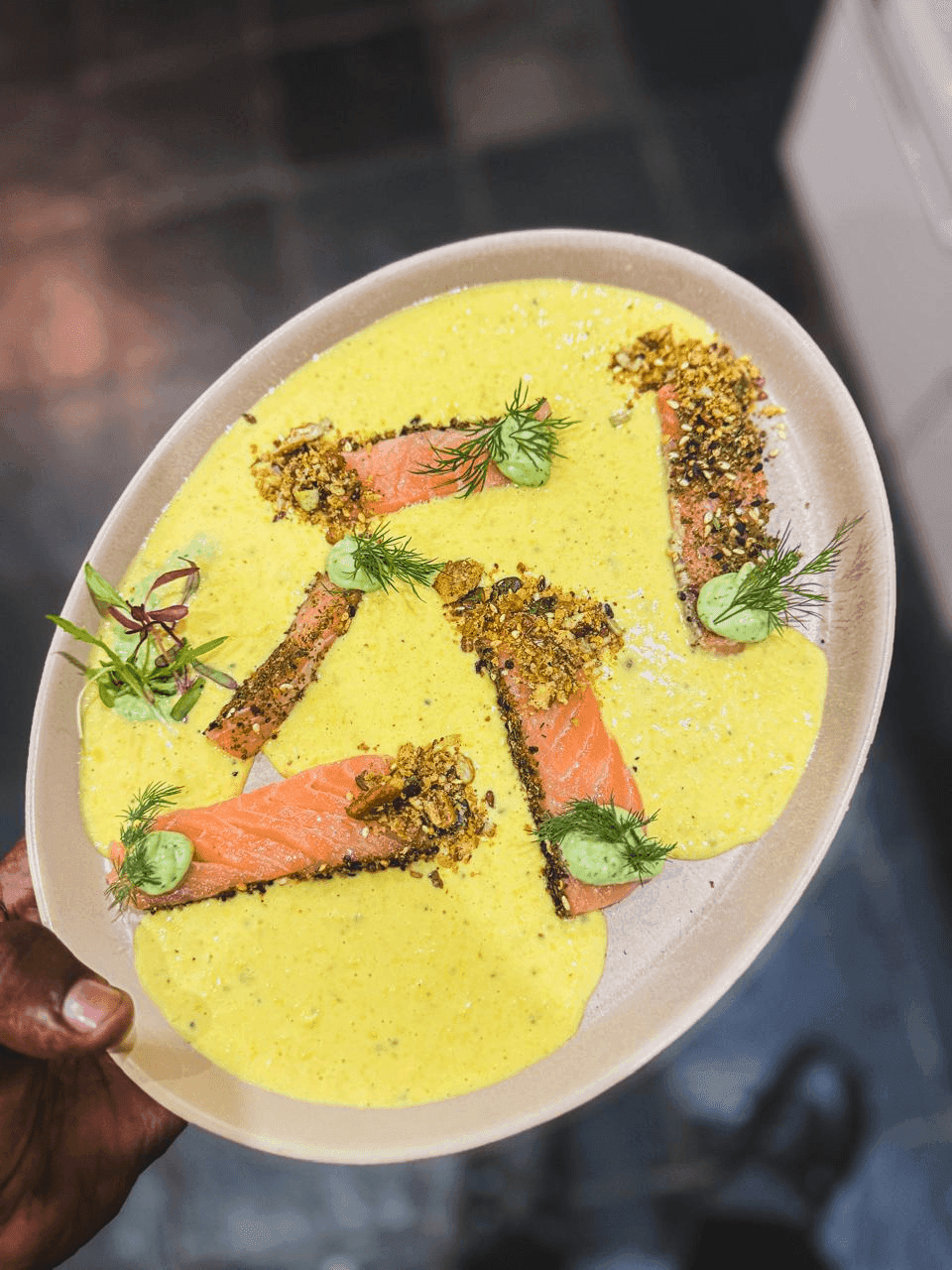 A sesame-crusted salmon course, plated with herb aioli and dukkah.