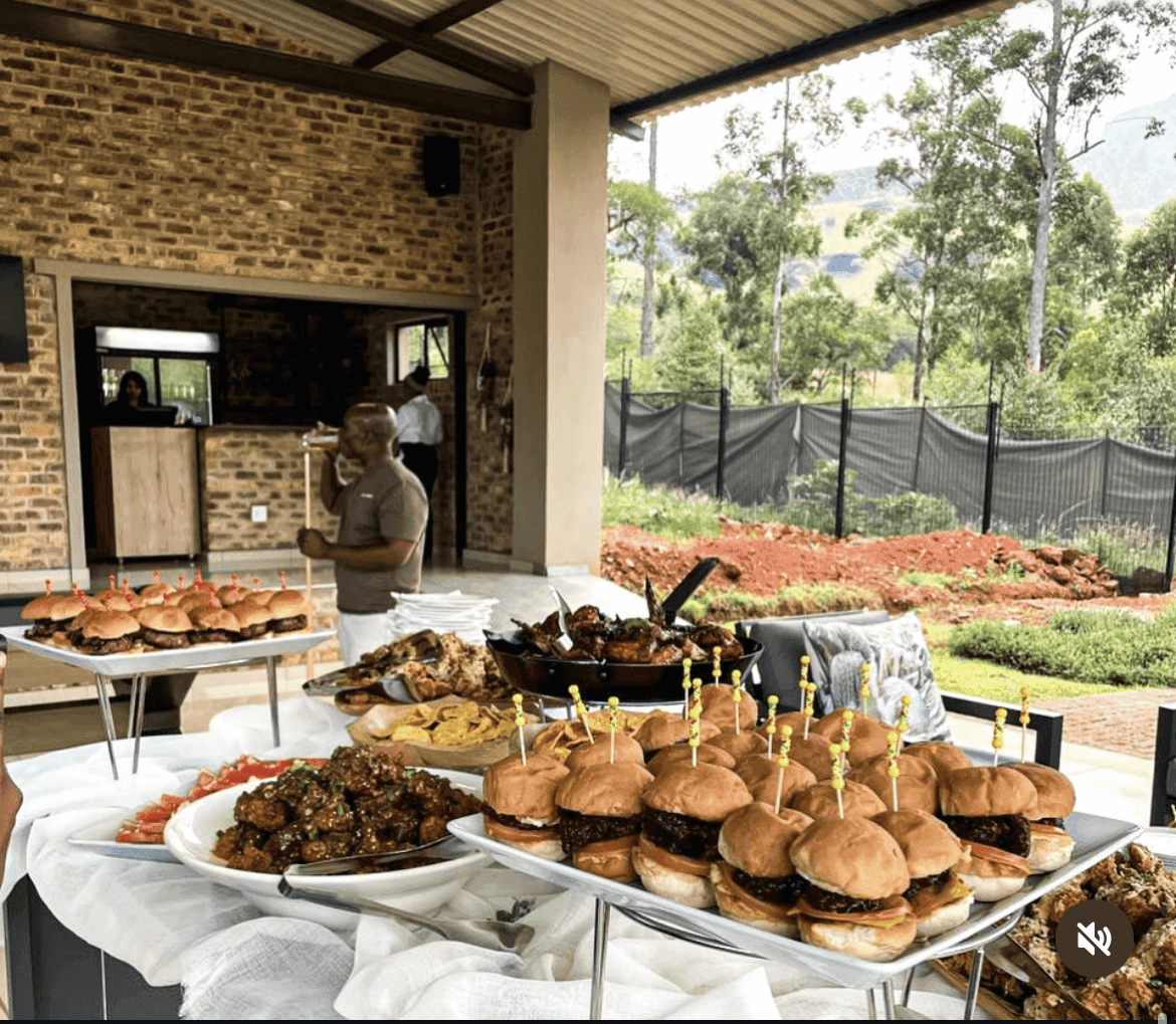 The buffet laid out on a covered patio with a Lowveld view.